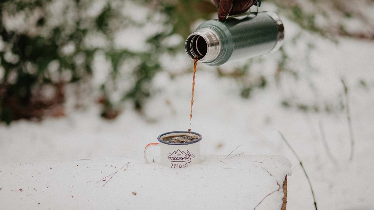 coffee cup depth photo of person holding vacuum flask filling cup portrait